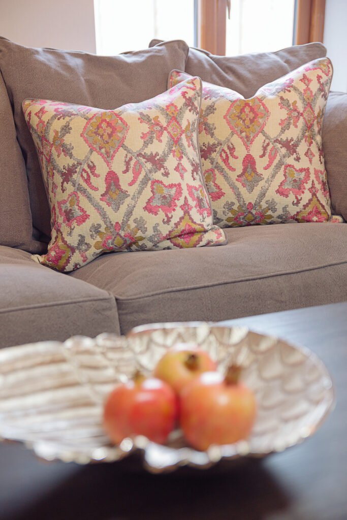 Decorative patterned cushions on a neutral sofa with fruit bowl on coffee table – Innishannon Showhouse by AK Interior, Cork Ireland.