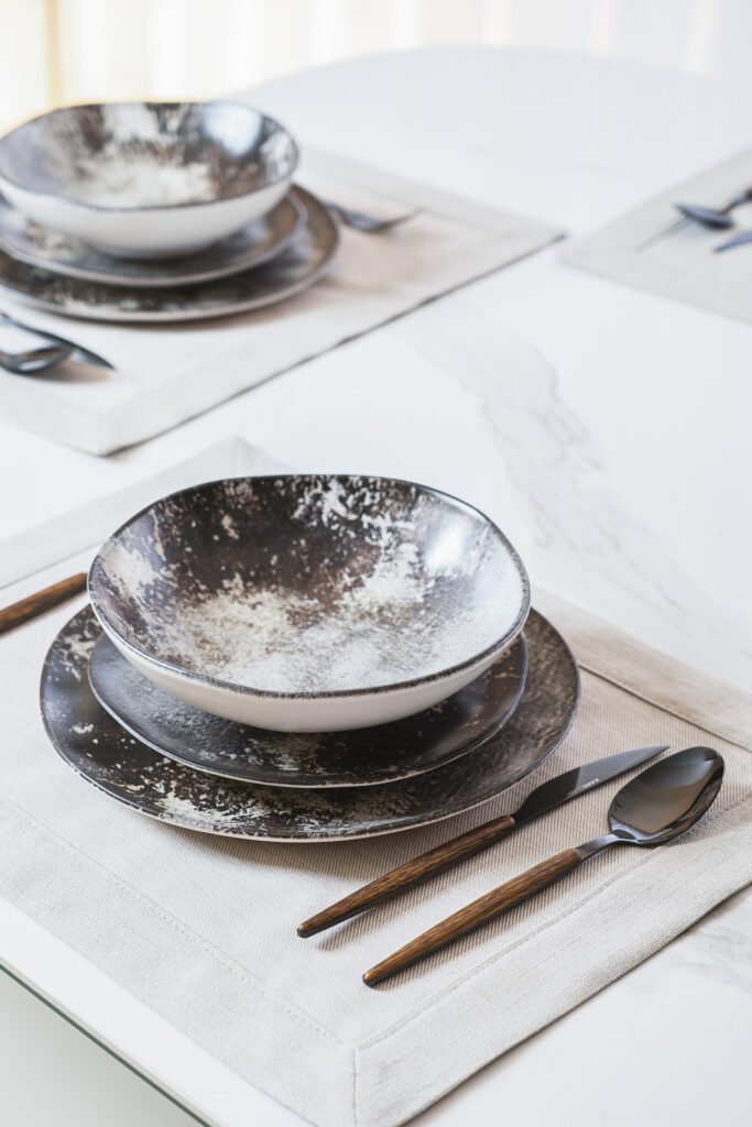 Close-up of grey ceramic plates and wooden tableware – Luxury Living Room Part Two by AK Interior.