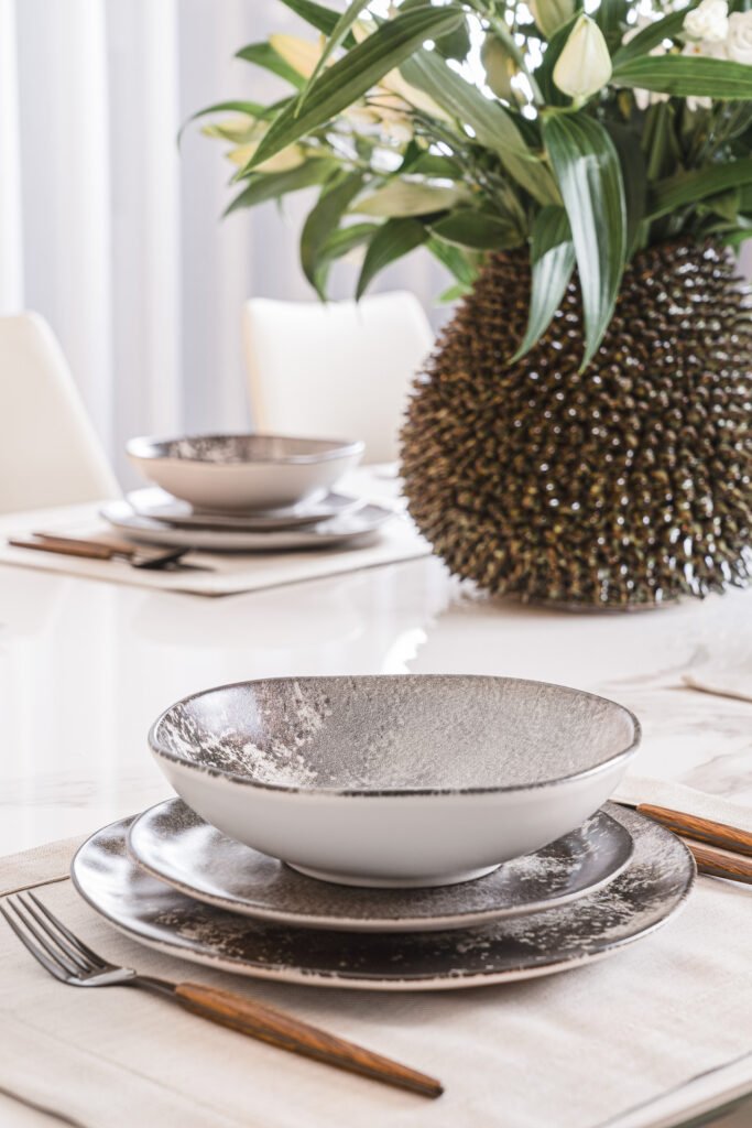 Modern ceramic bowl and plate set on neutral fabric – Luxury Living Room Part Two by AK Interior.