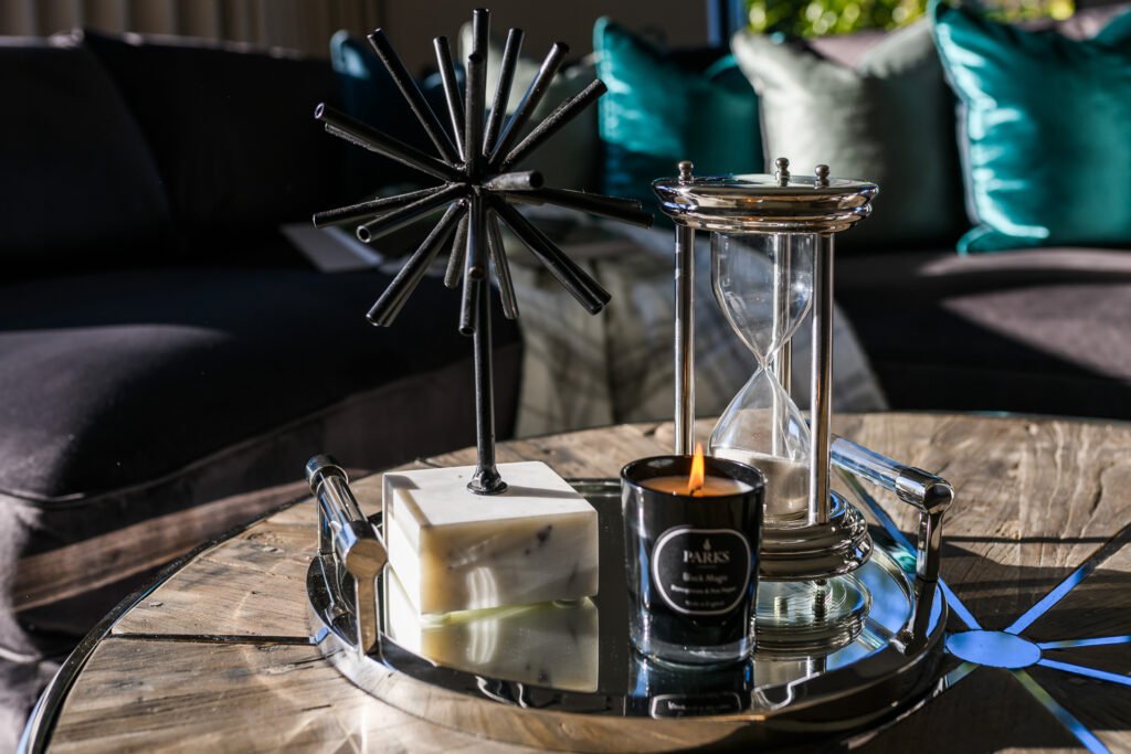 Coffee table vignette with black sculpture, hourglass and candle in front of teal cushions, Rathmore Residential project, AK Interior, Cork.