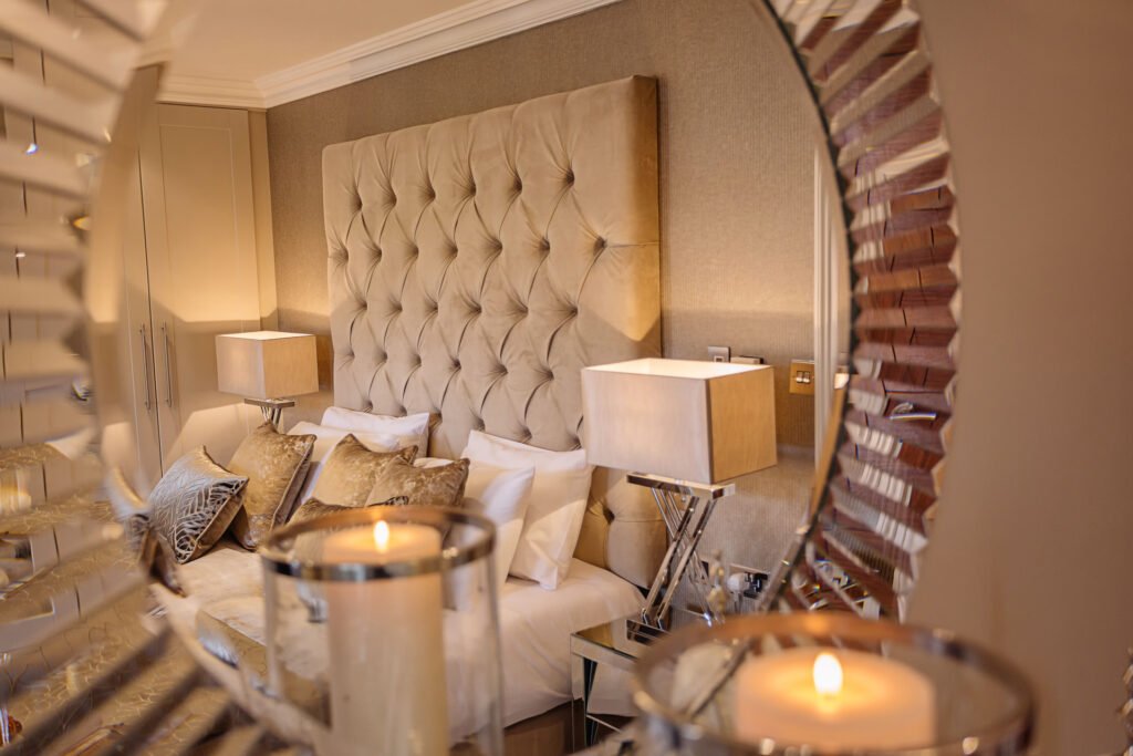 Warm bedroom with padded headboard, wooden wardrobes and mirrored bedside tables. Rockport Residential project, AK Interior, Cork.