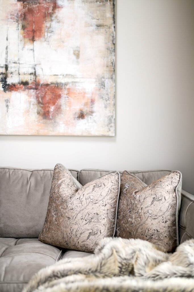 Decorative cushions on the sofa with an abstract artwork above – Whitegate Holiday Home, AK Interior, Cork