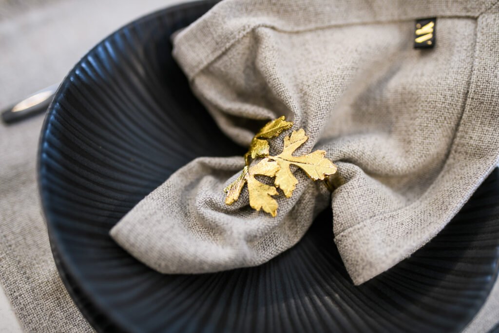 Black decorative plate with a napkin and gold accessory – Whitegate Holiday Home, AK Interior, Cork