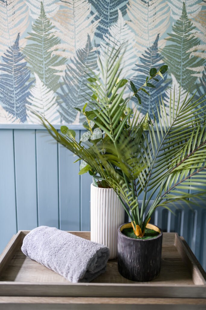 Plant in a vase on a decorative tray beside patterned wallpaper – Whitegate Holiday Home, AK Interior, Cork