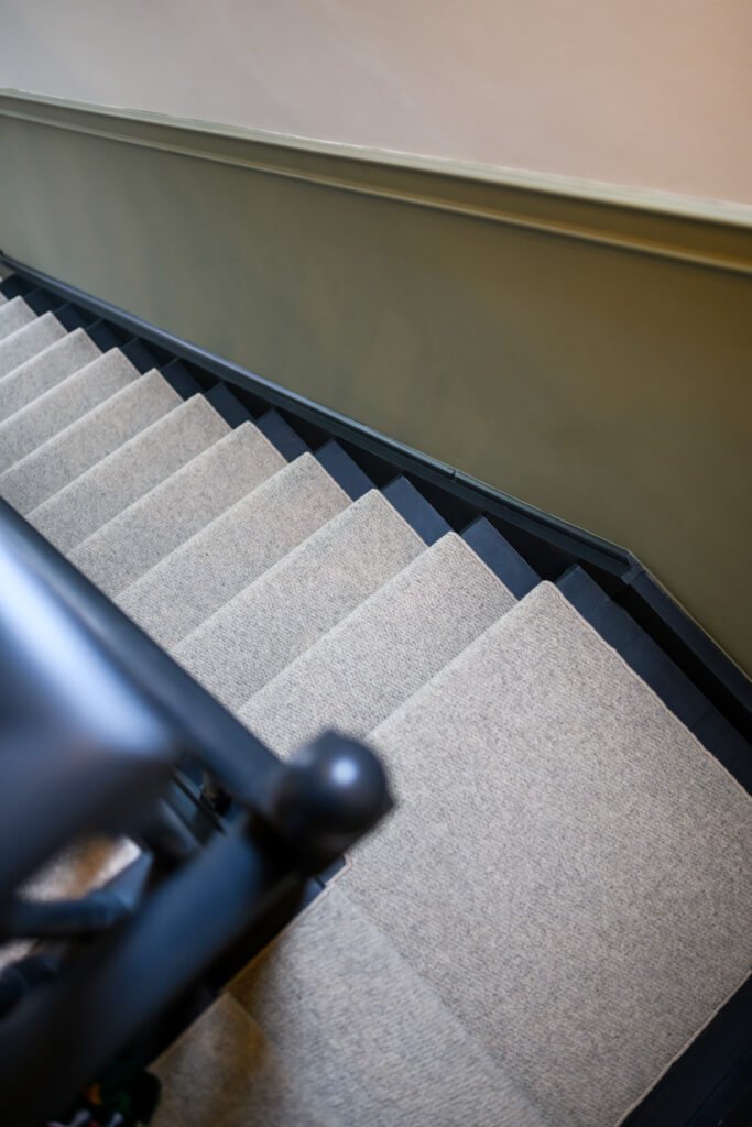 Carpeted staircase with green accent walls – Whitegate Holiday Home, AK Interior, Cork