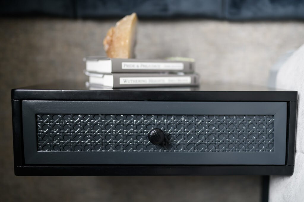 Floating dark bedside table with patterned drawer front, stacked books and crystal accent decor, AK Interior Design, Cork, Ireland