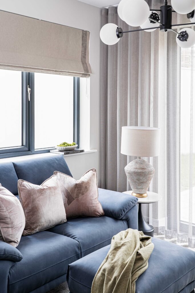 Blue sofa complemented with blush-toned cushions in a cozy living area – Residential project “The Steeples Part One”, designed by AK Interior, Cork, Ireland.