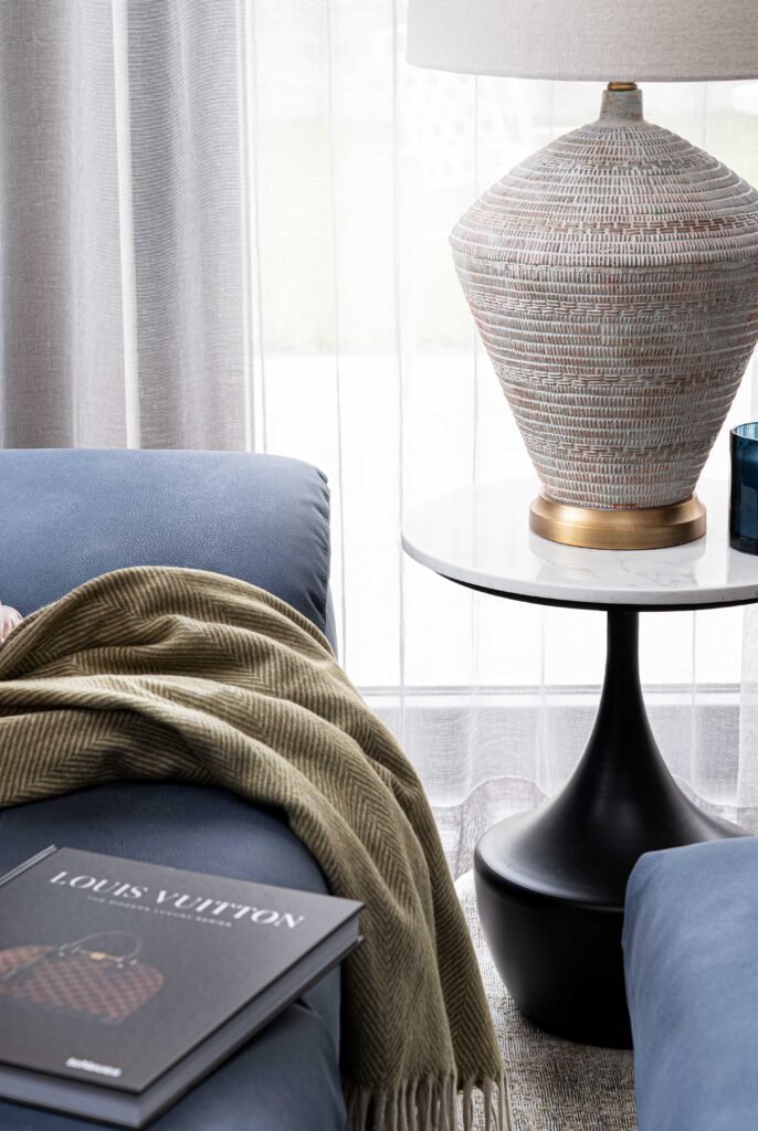 Close-up of blue sofa with textured throw and designer book – Residential project “The Steeples Part One”, designed by AK Interior, Cork, Ireland.