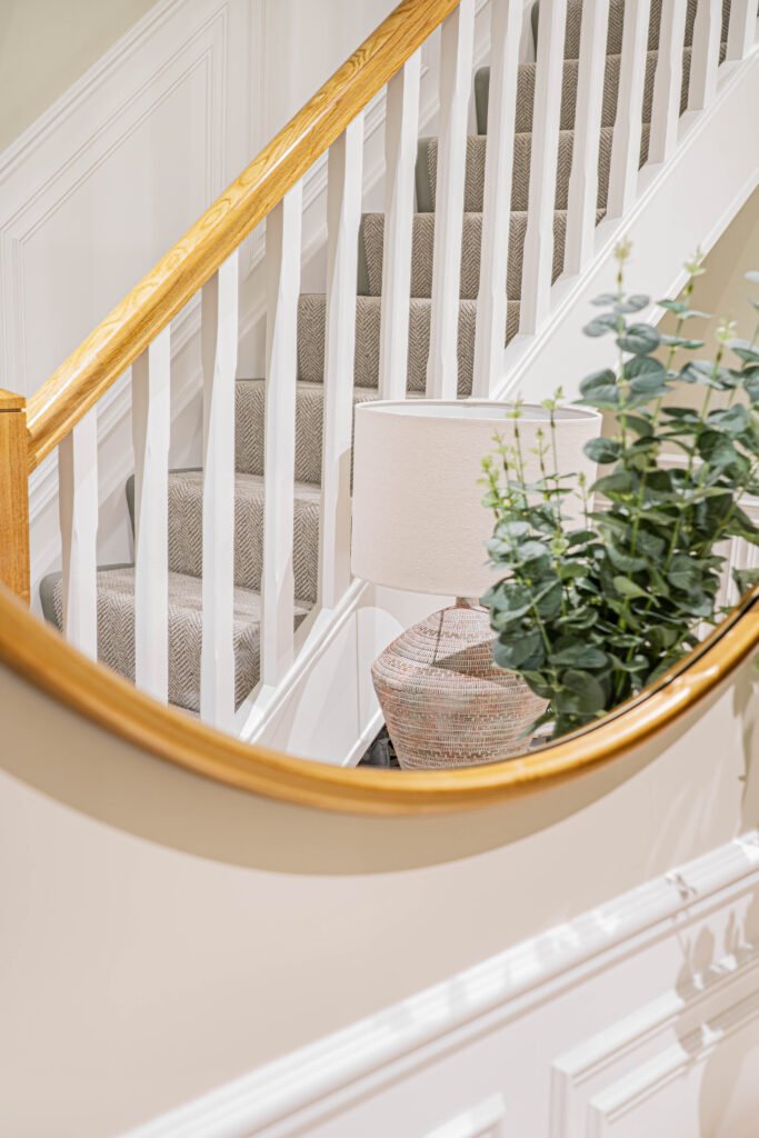 Landing staircase with curved wooden handrail and soft carpet runner — The Steeples Part One by AK Interior