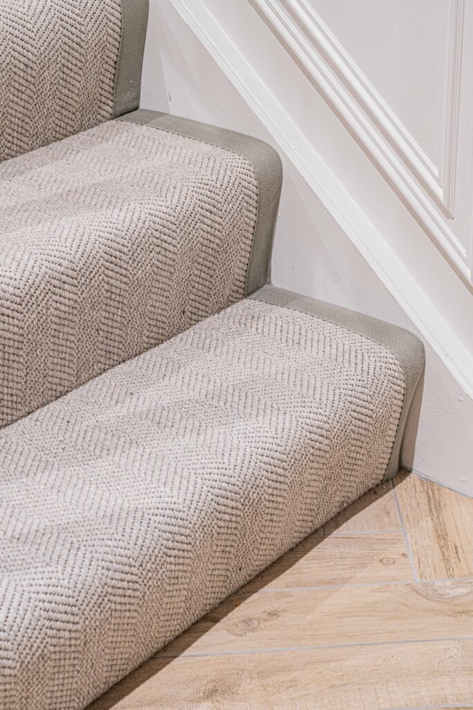 Carpeted staircase with white panelling and warm wooden handrail — The Steeples Part One by AK Interior