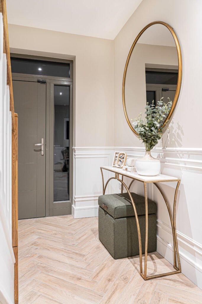 Bright entryway with wall panelling and soft grey carpeted stairs — The Steeples Part One by AK Interior