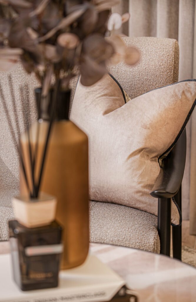 Beige armchair with neutral cushion and dried floral decor — The Steeples Part One by AK Interior