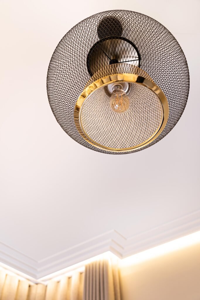 Round gold mirror with decorative sculpture and textured wall finish — The Steeples Part One by AK Interior