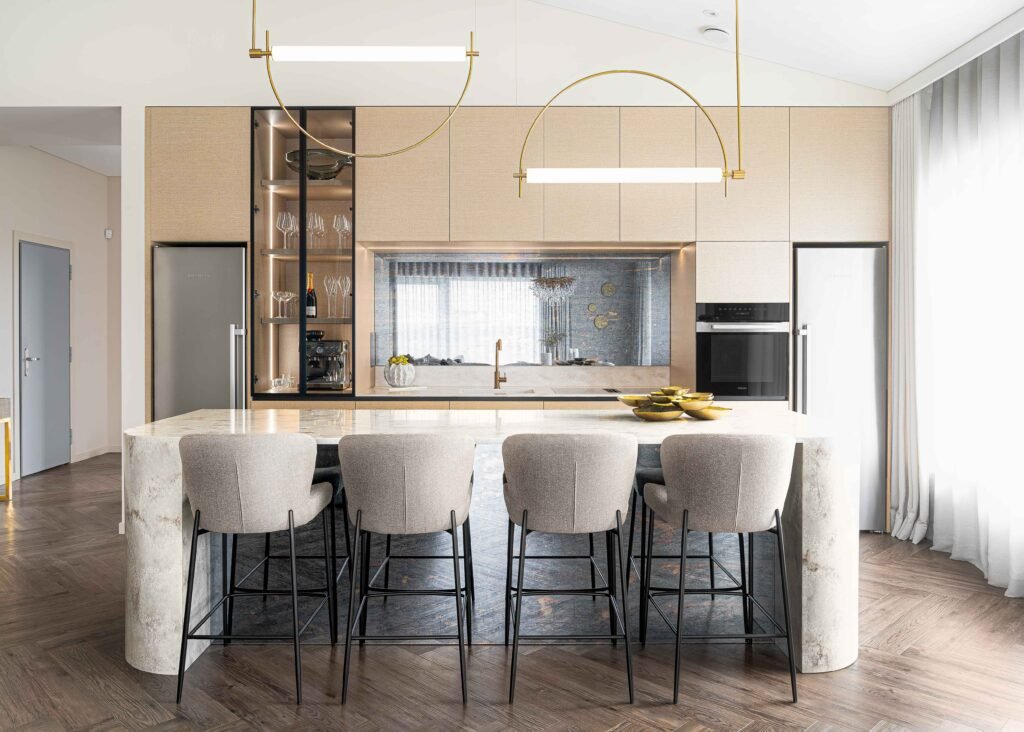 Modern kitchen with a stone island, soft bar stools and contemporary pendant lights – AK Interior Design, Cork