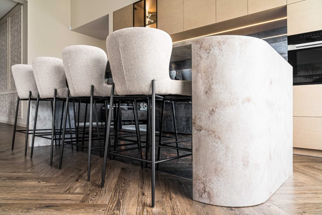 Curved stone kitchen island with soft upholstered bar stools – AK Interior Design, Cork