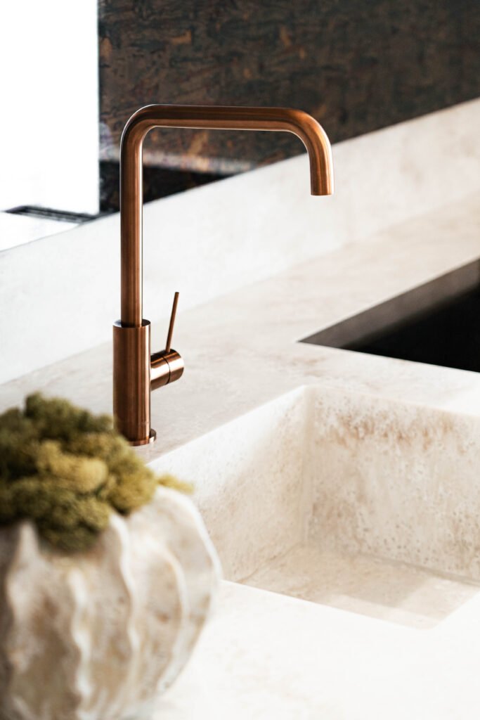 Bronze kitchen faucet on a stone sink surface | Monkstown Full House Design | AK Interior