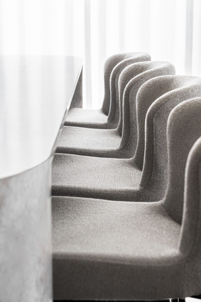Row of modern upholstered bar stools lined up along a kitchen island – AK Interior Design, Cork