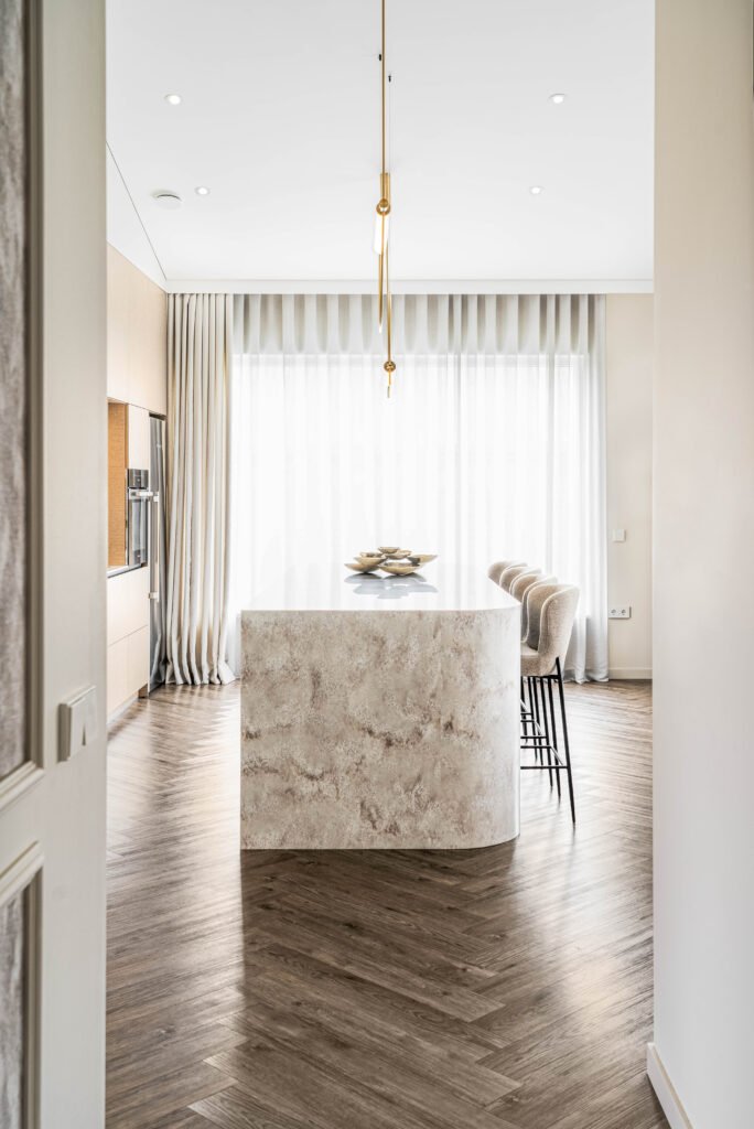 Marble-textured kitchen island with a gold pendant light | Monkstown Full House Design | AK Interior