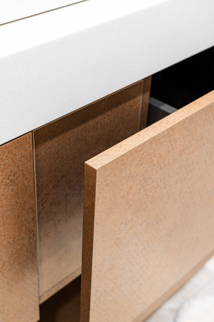Detail of handleless bathroom cabinet door opening below white worktop, AK Interior Design, Cork, Ireland.