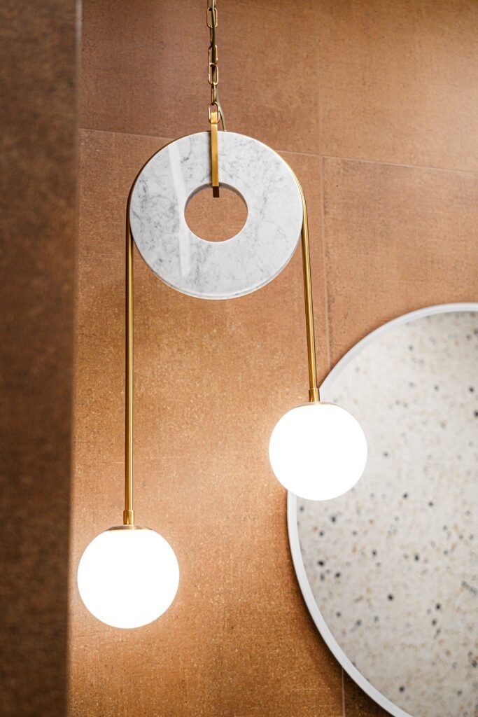 Modern pendant with marble disc and globe shades beside round terrazzo mirror, AK Interior Design, Cork, Ireland.