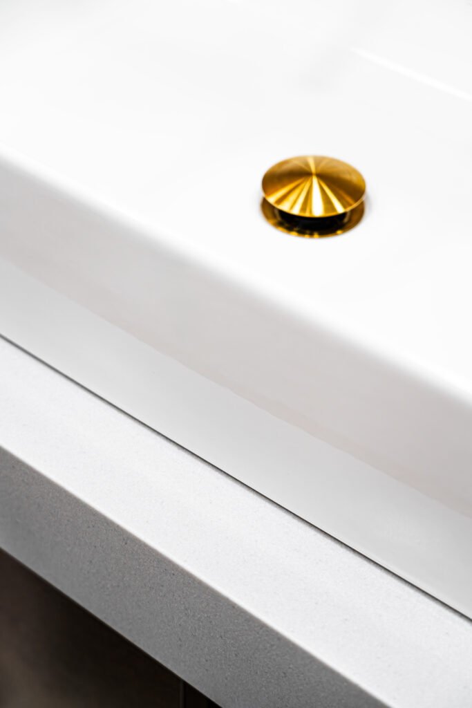 Minimal white basin with golden waste on pale quartz countertop, AK Interior Design, Cork, Ireland.