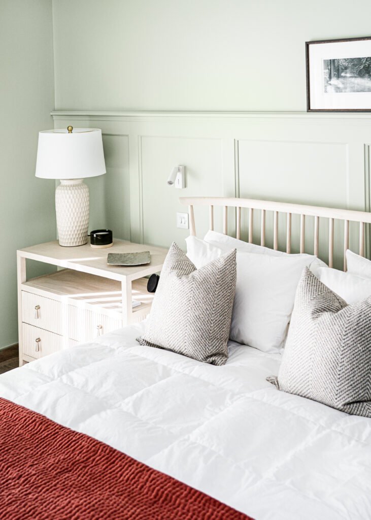 Close-up of bed with neutral cushions and white bedside table – West Cork Waterfront, residential project by AK Interior, Cork, Ireland.