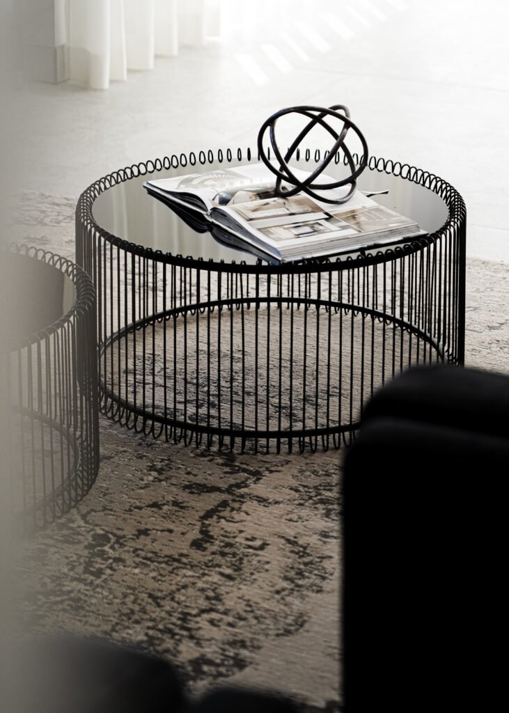 Living room vignette with circular coffee table on patterned rug. Rosscarbery Residence residential project, AK Interior.