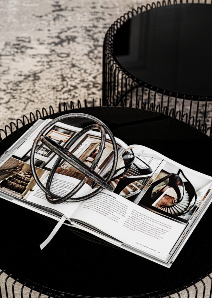 Round black wire coffee table styled with books and sculptural object. Rosscarbery Residence residential project, AK Interior.