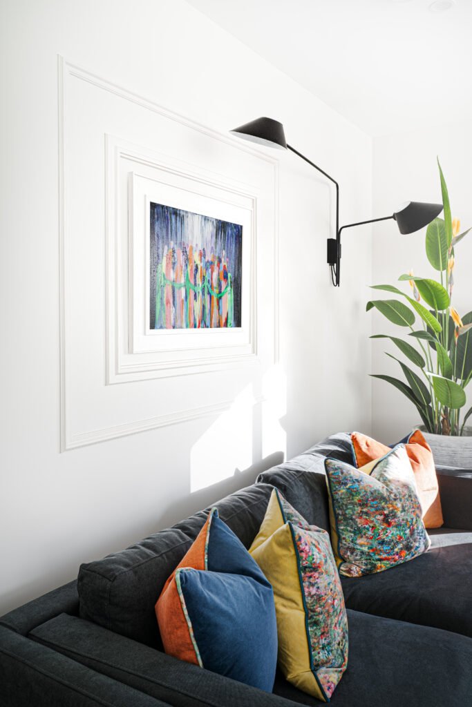 Cosy corner sofa with layered cushions and wall-mounted reading light. Rosscarbery Residence residential project, AK Interior.