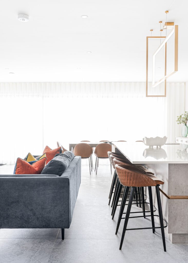 Open-plan kitchen, dining and living space with navy sofa and island. Rosscarbery Residence residential project, AK Interior.