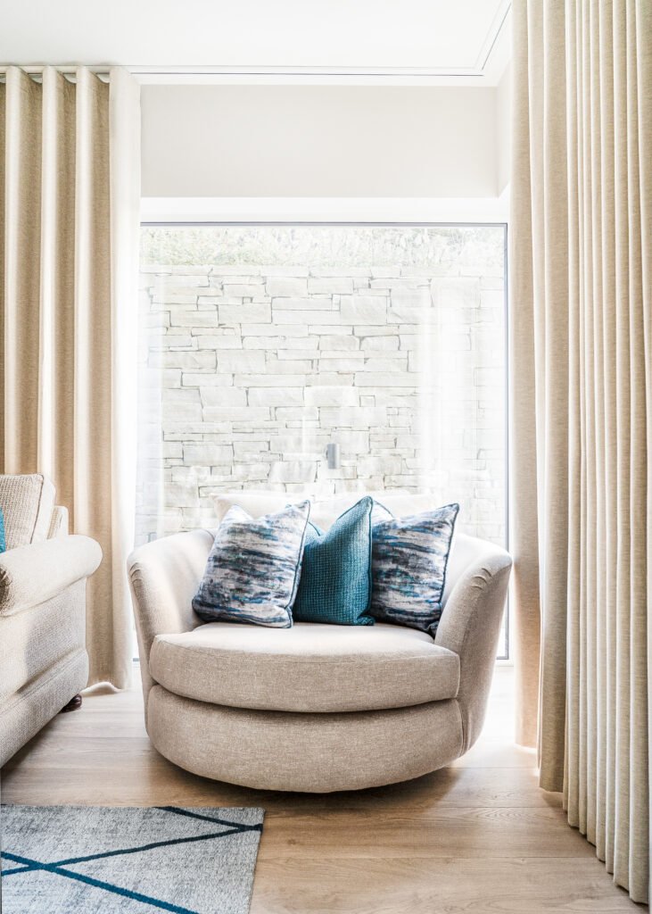 Cosy reading nook with round armchair by full-height window. Rosscarbery Residence residential project, AK Interior.