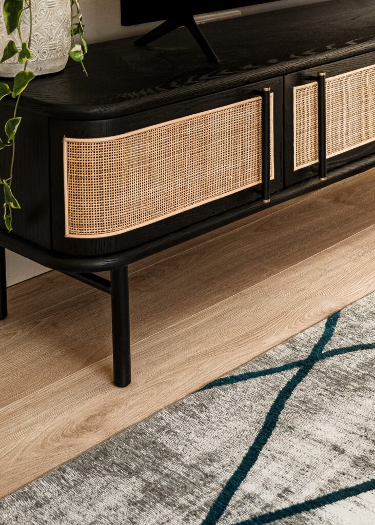 Close-up of black sideboard with cane doors and slim brass legs. Rosscarbery Residence residential project, AK Interior.