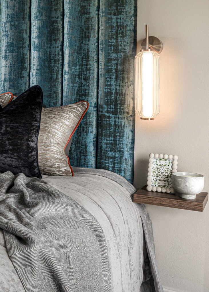 Bedroom with teal velvet headboard and warm wall-mounted lighting – Dingle project, designed by AK Interior, Cork, Ireland.