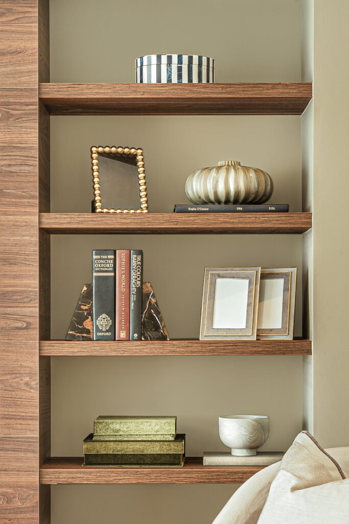 Styled wooden shelves with books, framed photos and sculptural decor, Rosscarbery Reading Room, AK Interior, Cork.