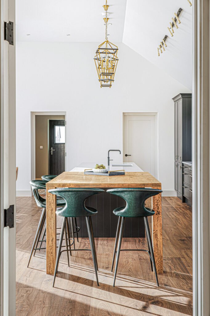 Dining area with upholstered chairs and contemporary chandelier – Dingle project, designed by AK Interior, Cork, Ireland.