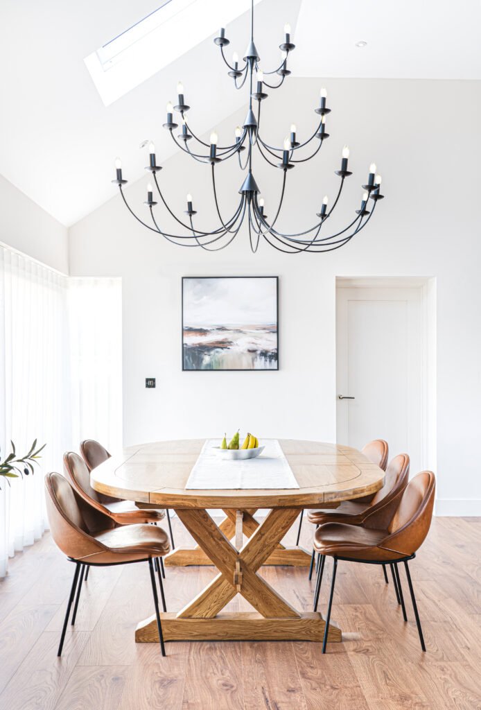 Dining area with wooden table and modern black chandelier – Dingle project, designed by AK Interior, Cork, Ireland.