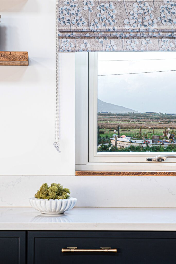 Kitchen window with patterned Roman blind overlooking countryside – Dingle project, designed by AK Interior, Cork, Ireland.