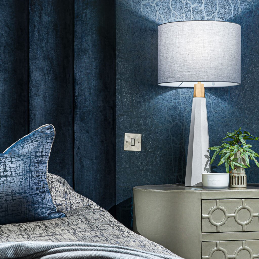 Close-up of bed with deep blue headboard, decorative cushions and grey throw – Youghal Residential, AK Interior, Cork
