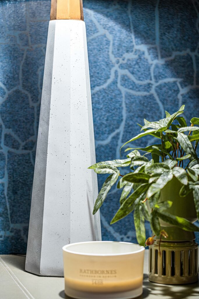 White concrete table lamp with green plant and scented candle on cabinet – Youghal Residential, AK Interior, Cork