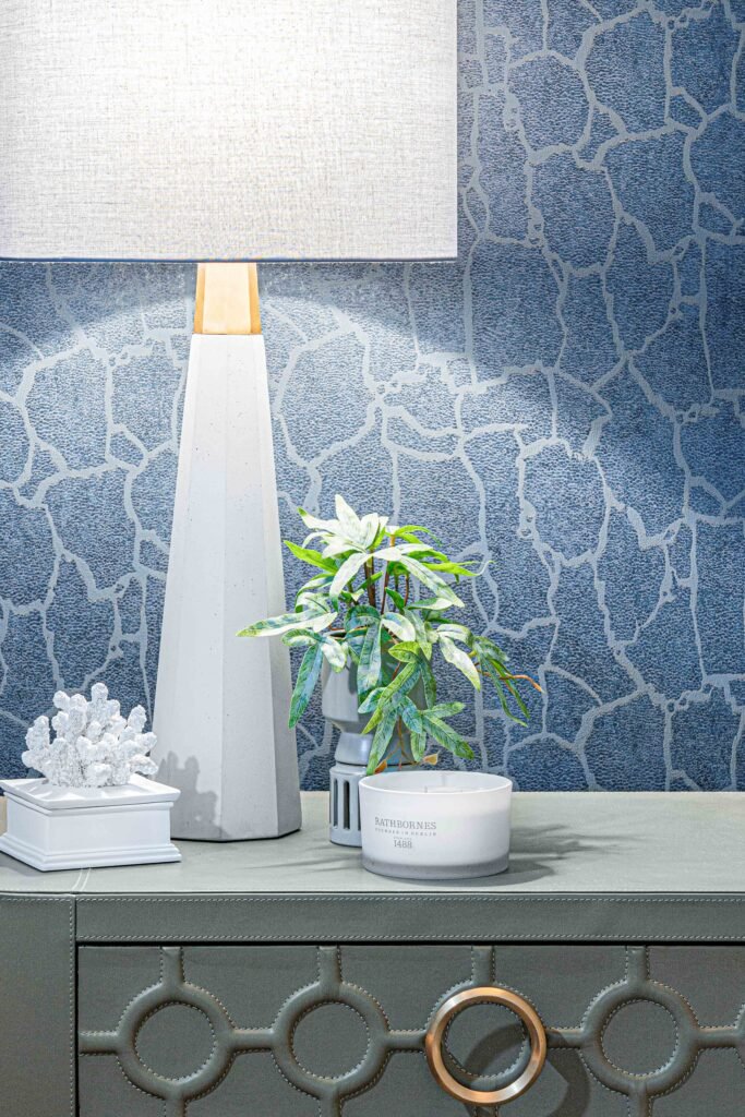 Bedside cabinet with white lamp, green plant, coral ornament and scented candle – Youghal Residential, AK Interior, Cork