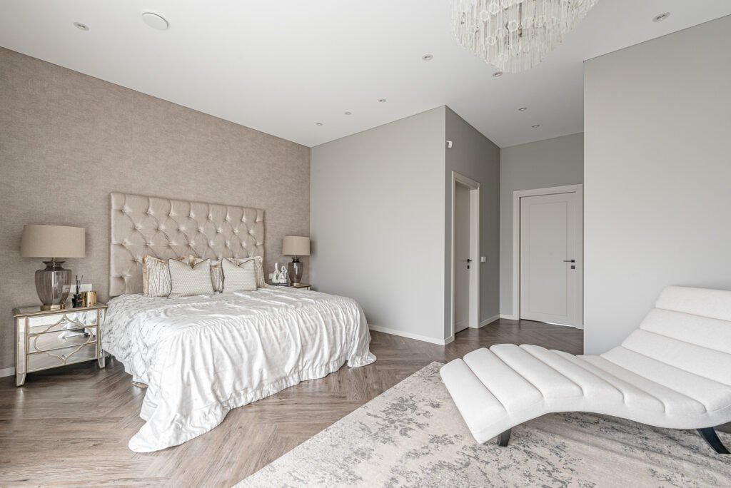 Spacious bedroom with neutral tones, decorative headboard and window leading to the terrace – AK Interior, Monkstown Full House Design