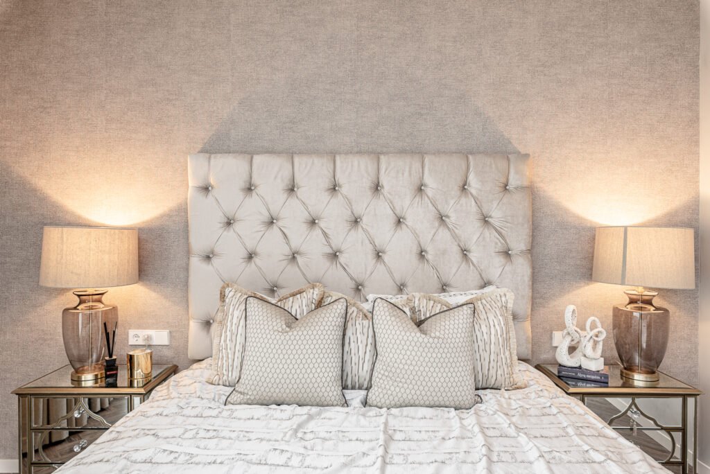 Bright bedroom interior with a tall tufted headboard, mirrored nightstands and warm ambient lighting – AK Interior, Monkstown Full House Design