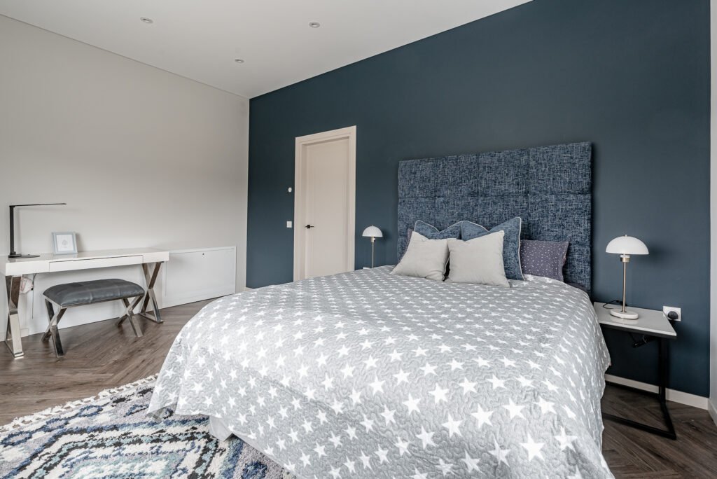 Bedroom with blue accent wall and star-patterned bedspread – Monkstown Full House Design – AK Interior