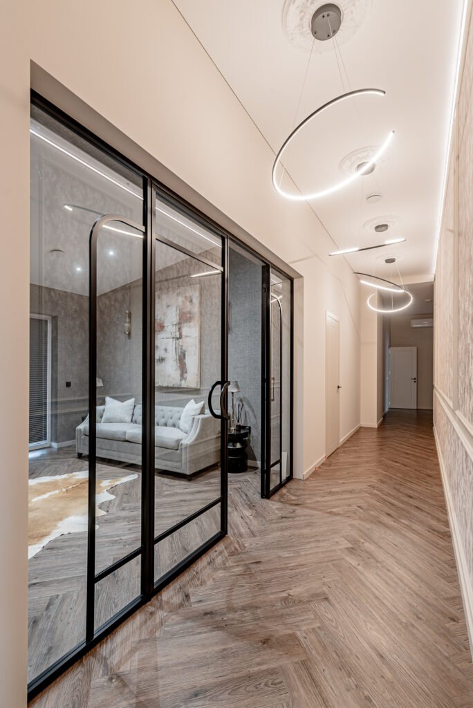 Modern hallway with black-framed glass partitions and curved LED ceiling lights – Monkstown Full House Design – AK Interior